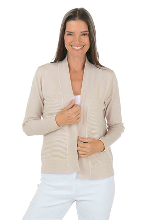 Woman wearing a beige cardigan over a white top on a white background.
