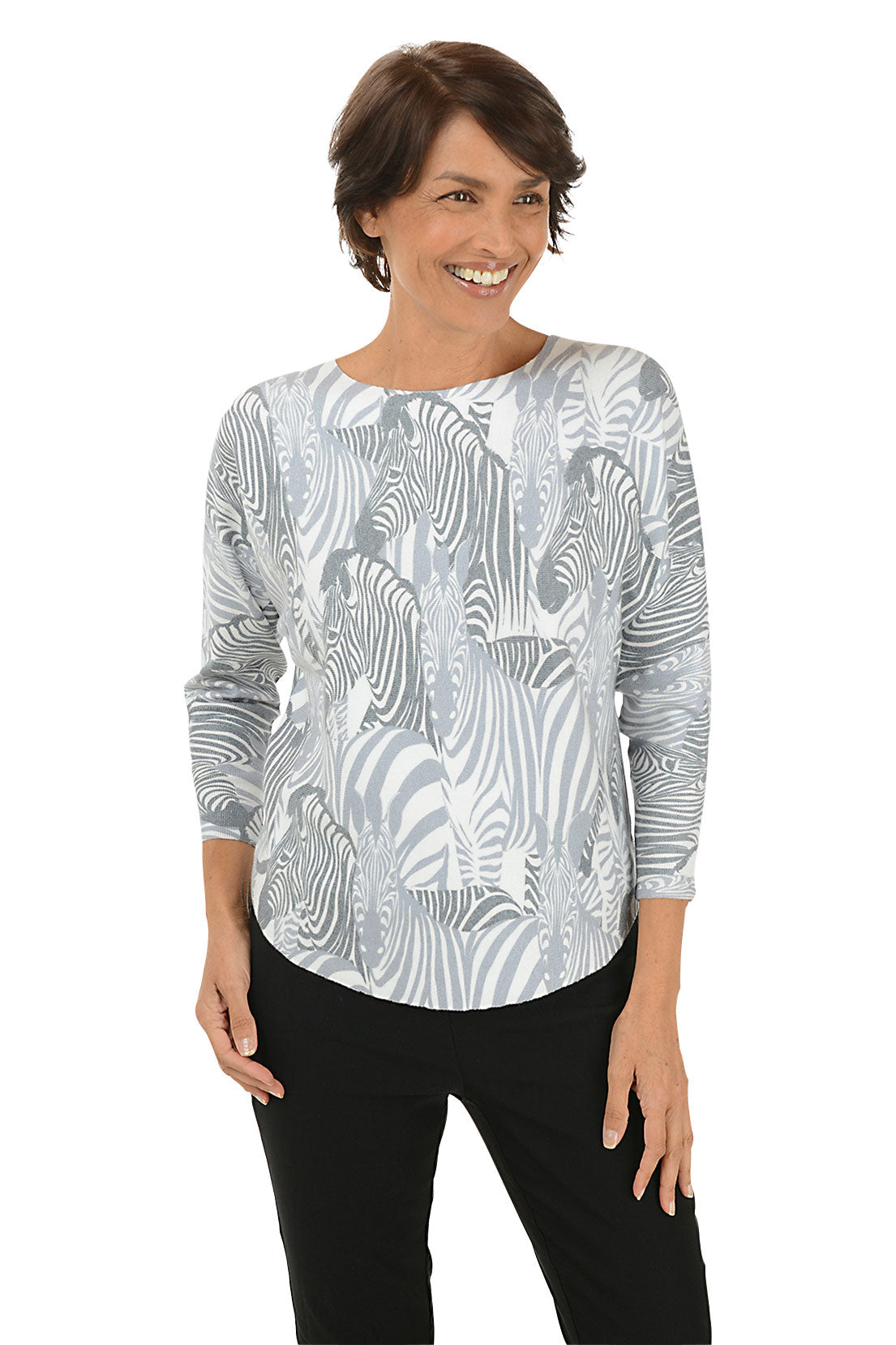 Woman wearing a grey and white zebra illustrated patterned long-sleeve top on a white background. 