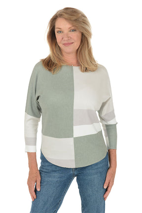 Woman wearing a color-blocked sweater with green and white sections on a white background. Second front shot.