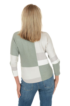 Woman wearing a color-blocked sweater with green and white sections on a white background. Back shot.