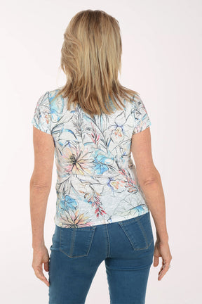 Woman wearing a floral top and blue jeans on a white background