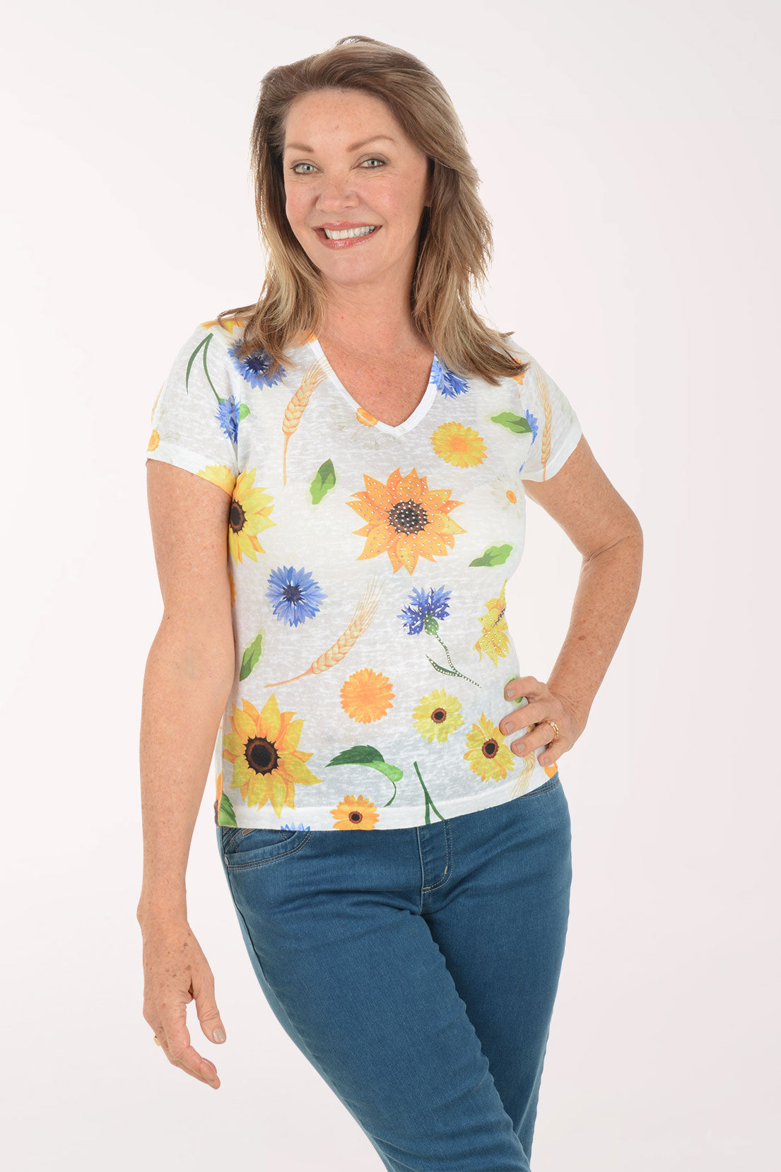 Woman wearing a floral-patterned shirt with blue jeans on a white background