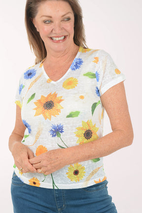 Woman wearing a floral-patterned shirt with blue jeans on a white background