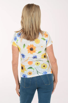 Woman wearing a floral-patterned shirt with blue jeans on a white background