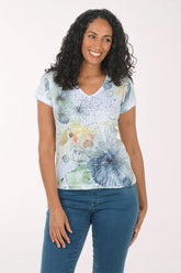 Woman wearing a colorful floral-patterned shirt against a white background