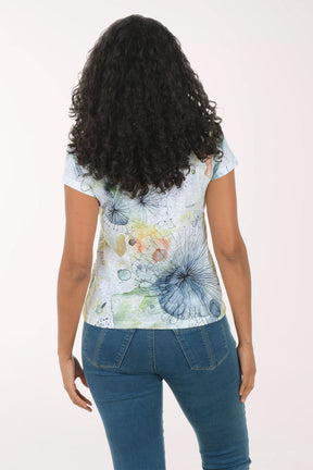 Woman wearing a colorful floral-patterned shirt against a white background