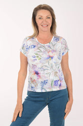 Woman wearing a floral-patterned shirt and blue jeans on a white background