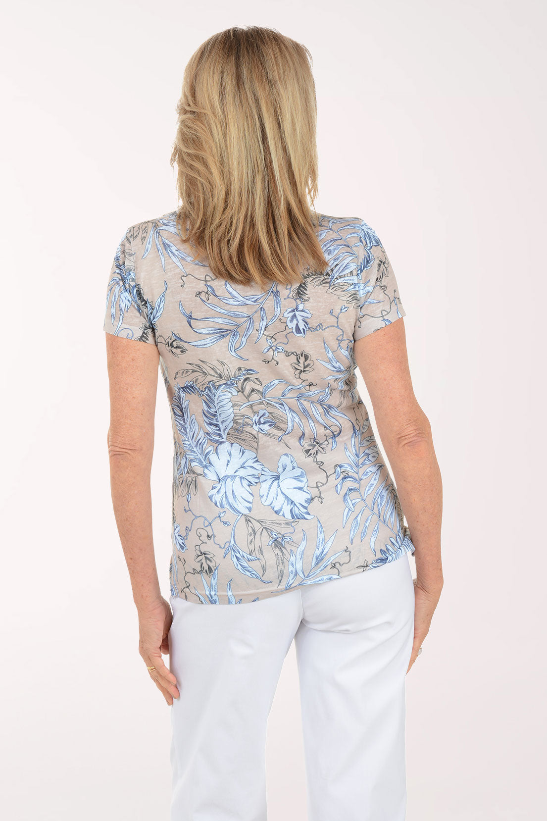 Woman wearing a colorful floral blouse against a white background