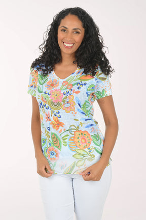Woman wearing a colorful floral blouse against a white background