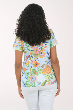 Woman wearing a colorful floral blouse against a white background