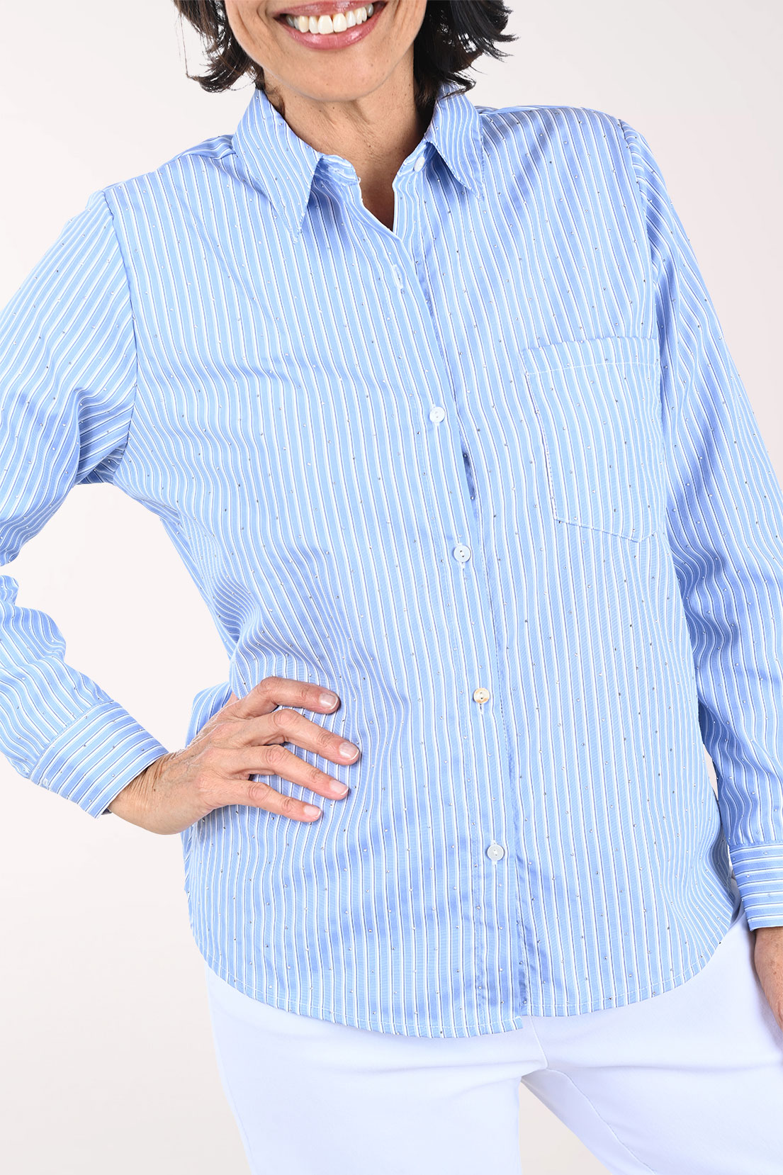Woman wearing a blue striped shirt against a white background