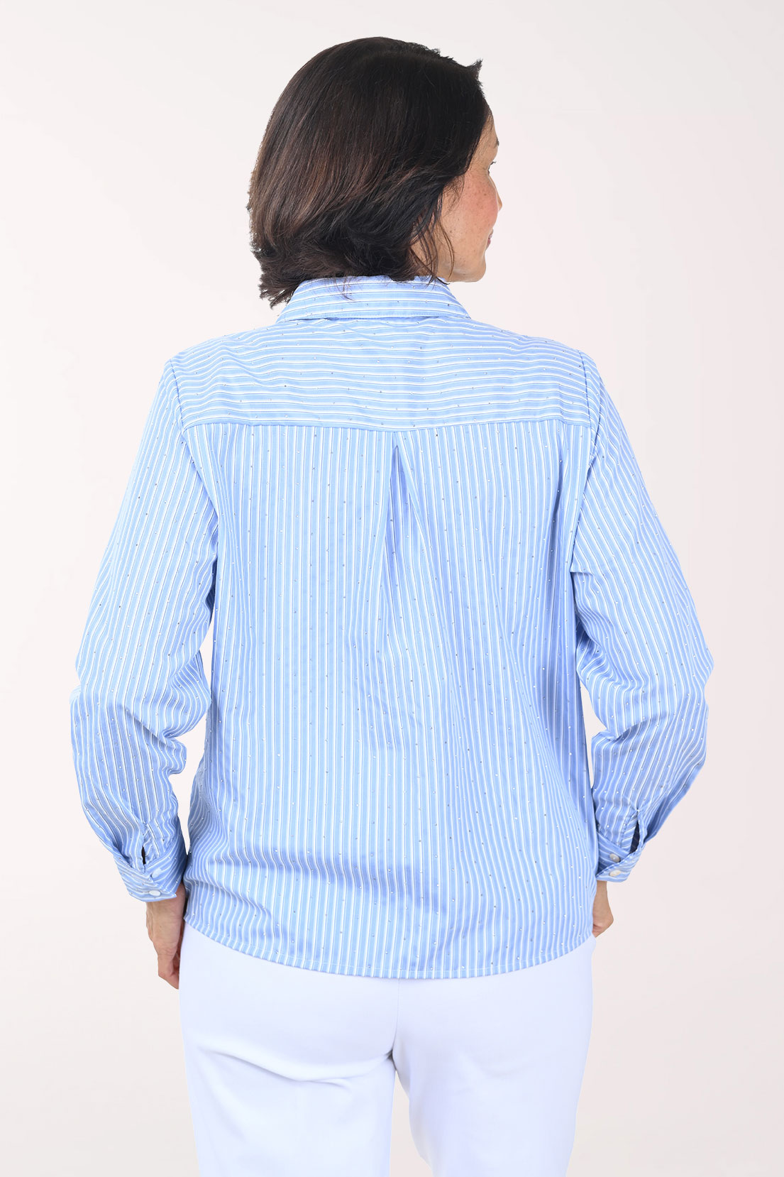 Woman wearing a blue striped shirt against a white background
