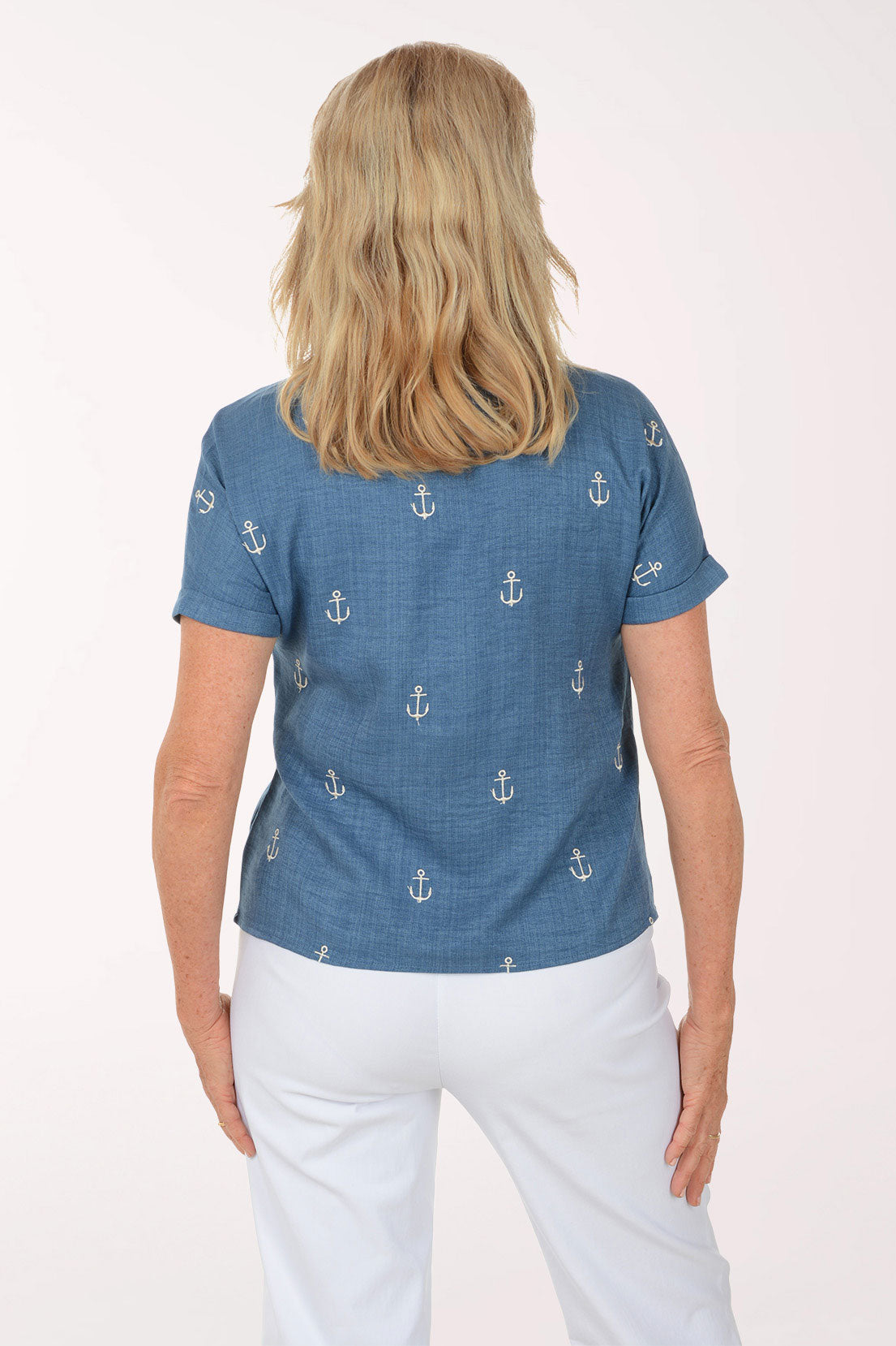 Woman wearing a blue shirt with anchor patterns on a white background