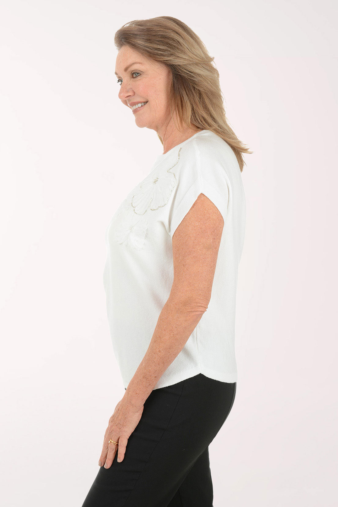 Woman wearing a white blouse with ruffled sleeves on a white background