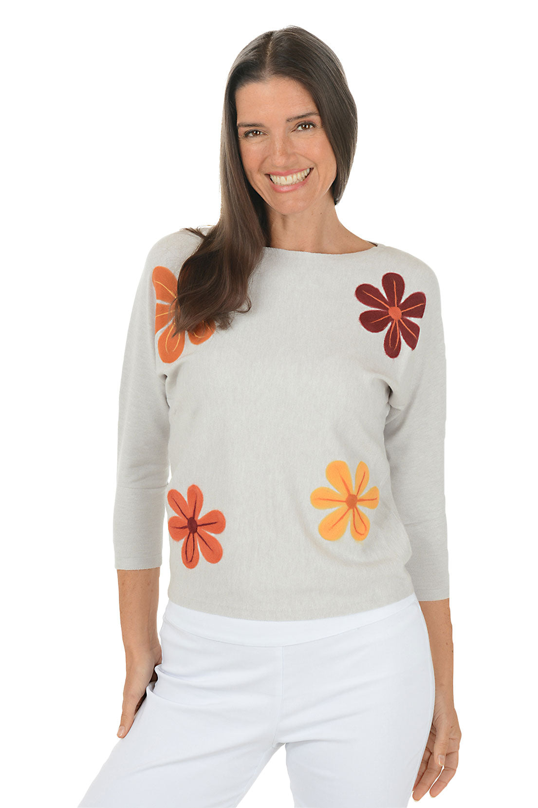 Woman wearing a gray sweater with colorful flower patterns on a white background.