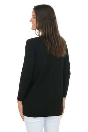 Woman wearing a black cardigan with gold floral designs on a white background. Back shot.