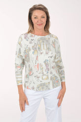 Woman wearing a long-sleeve top with colorful graphic design on a white background