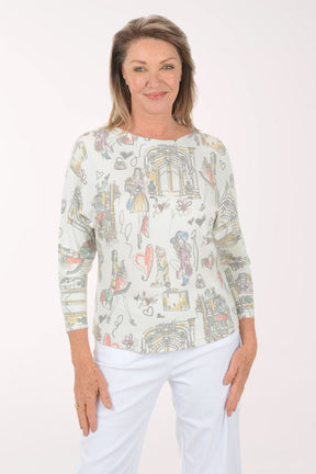Woman wearing a long-sleeve top with colorful graphic design on a white background
