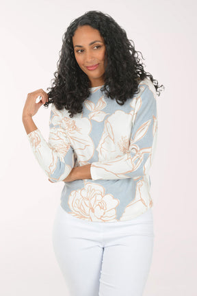 Woman wearing a light blue floral-patterned sweater against a white background