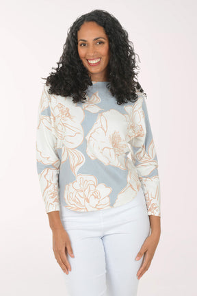 Woman wearing a light blue floral-patterned sweater against a white background