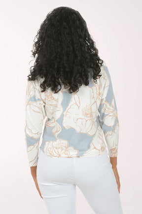 Woman wearing a light blue floral-patterned sweater against a white background