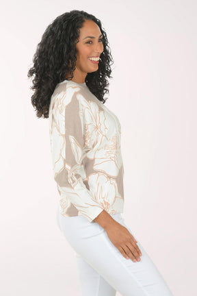 Woman wearing a floral blouse and light blue pants on a white background