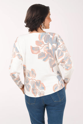 Woman wearing a floral blouse and blue jeans on a white background