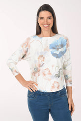 Woman wearing a floral blouse and blue jeans on a white background