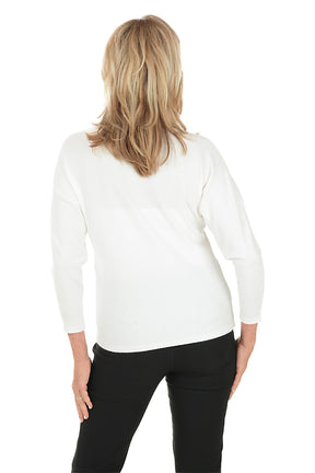 Woman wearing a white sweater with decorative cut-out patterns on a white background. Back shot.
