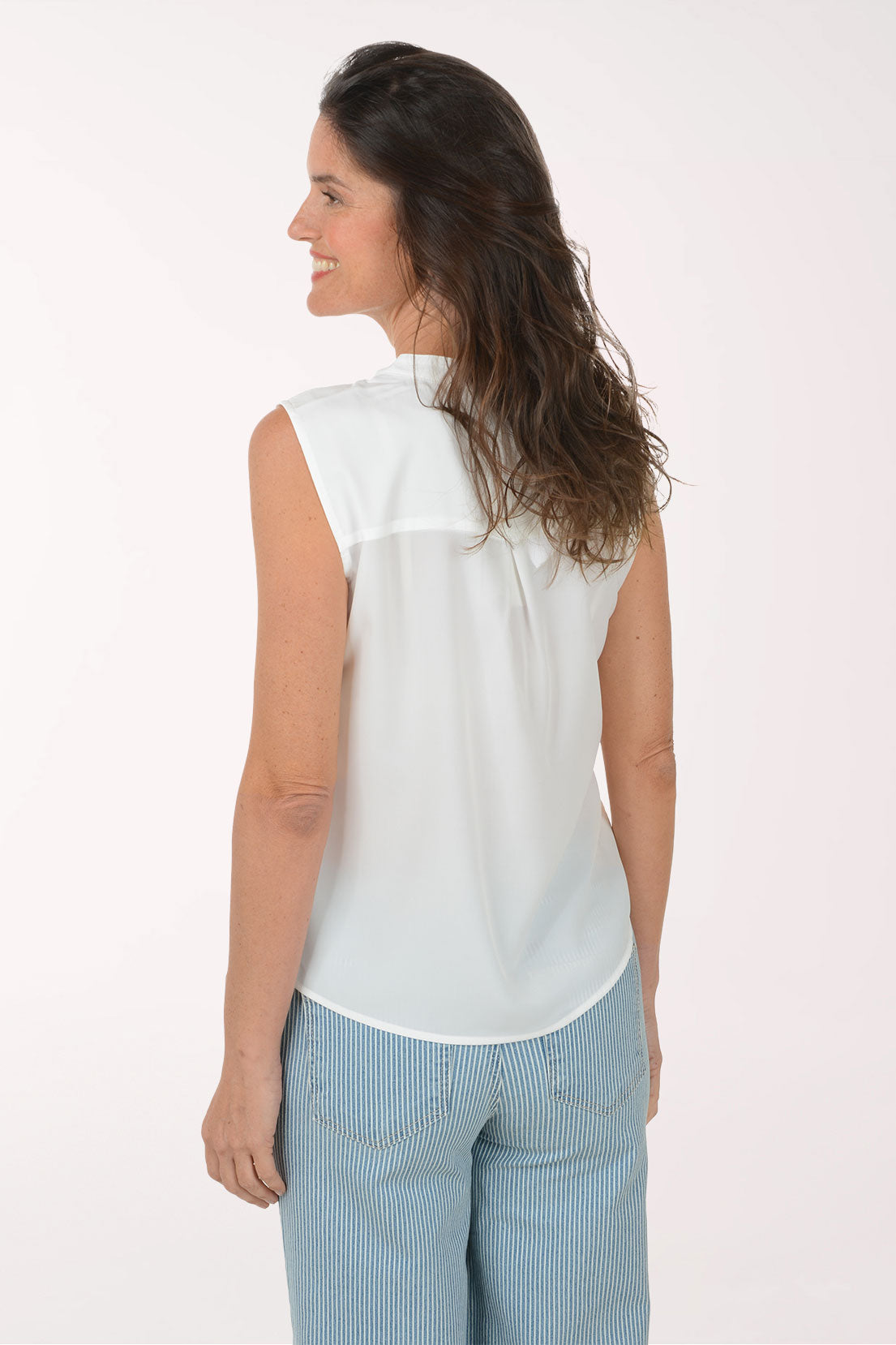 Woman wearing a white sleeveless collarless blouse