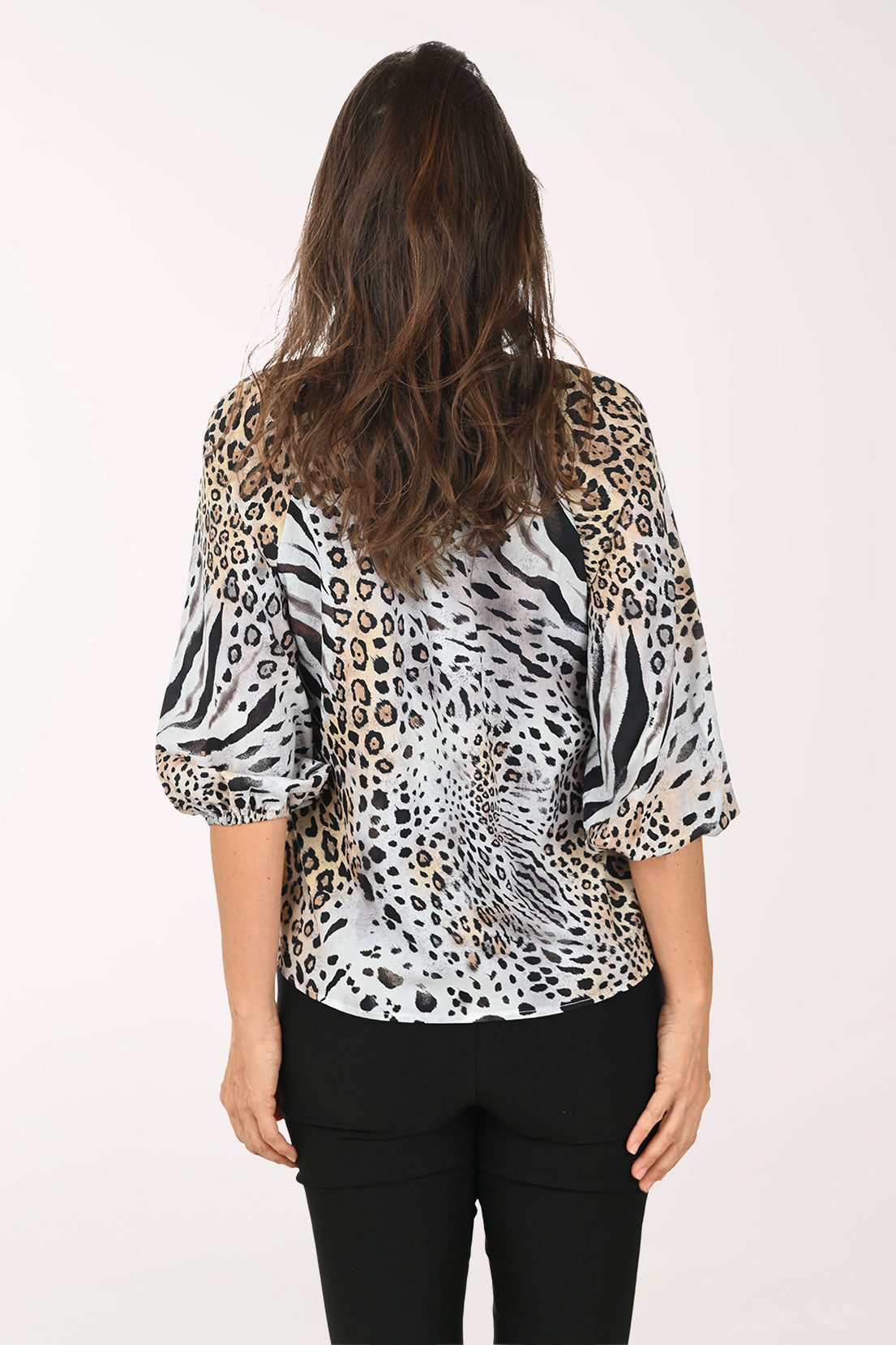 Woman wearing an animal print button down top.