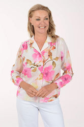 Woman wearing a floral blouse with pink flowers on a white background