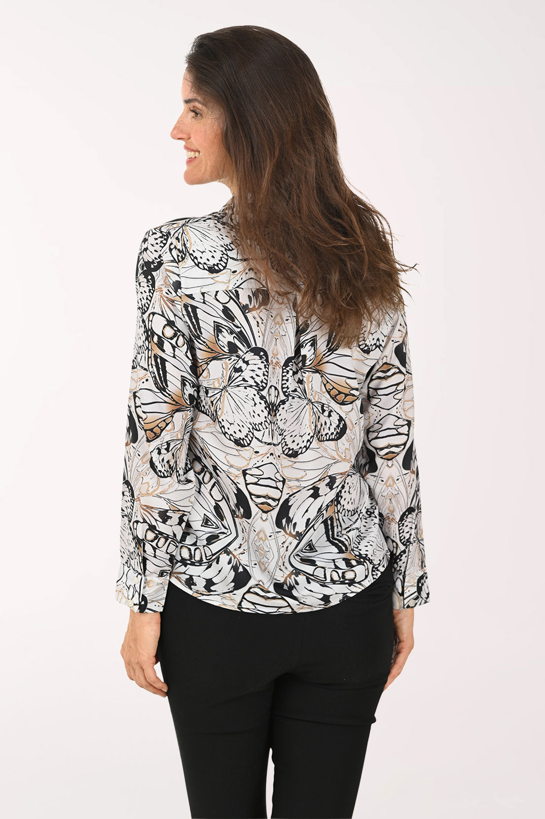 Woman wearing a black long sleeve shirt with a butterfly print.