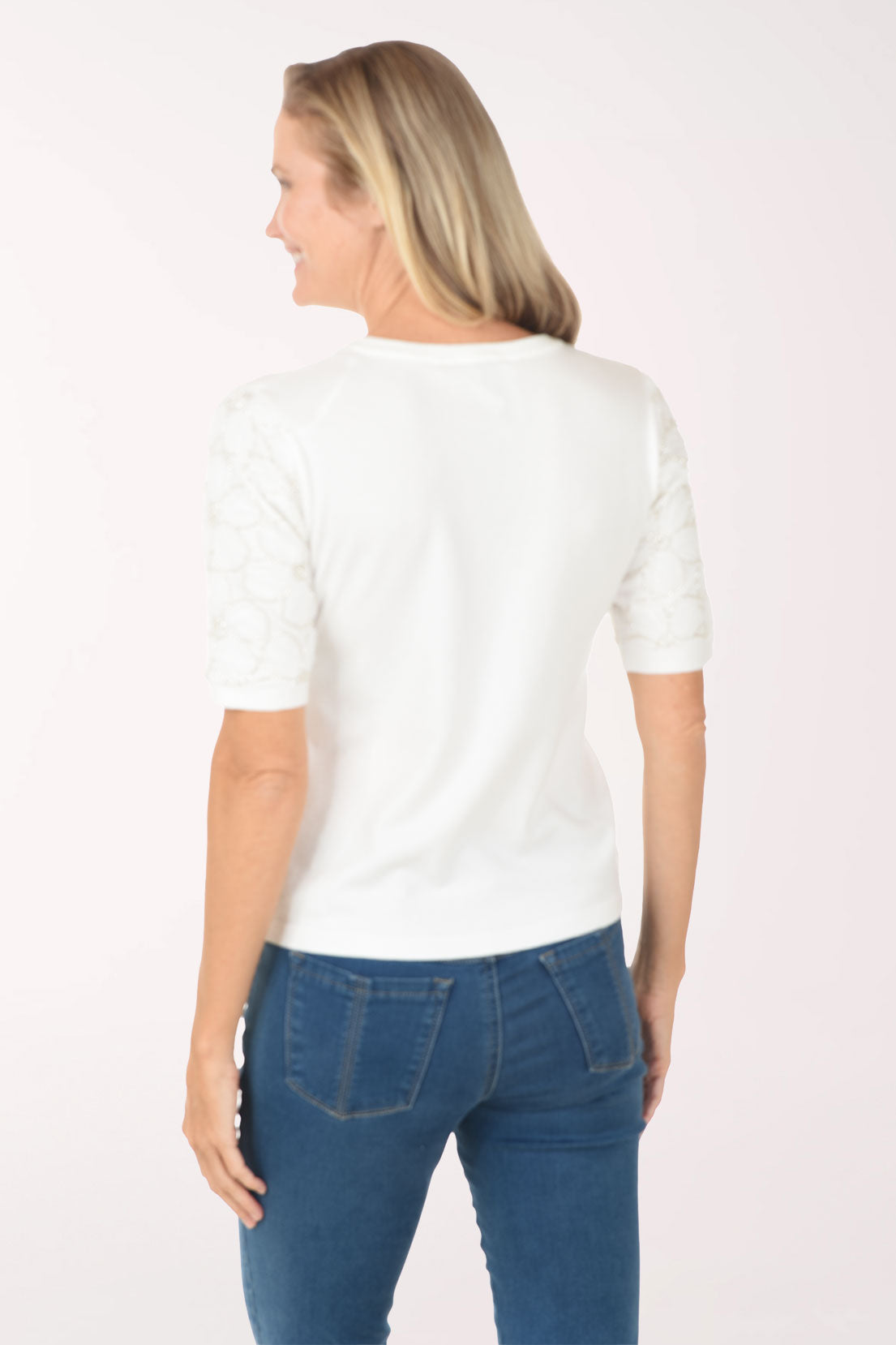 Woman wearing a white t-shirt and blue jeans on a white background