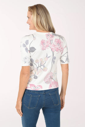 Woman wearing a floral top and blue jeans on a white background
