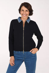 Woman wearing a black zip-up sweater jackets with a denim collar