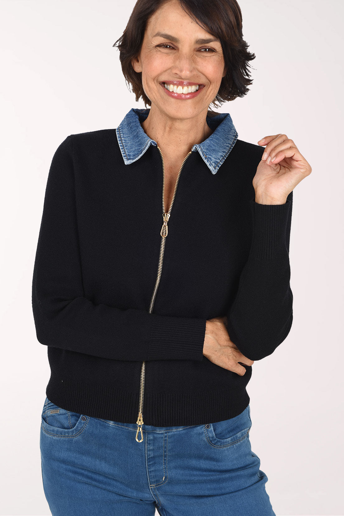 Woman wearing a black zip-up sweater jackets with a denim collar
