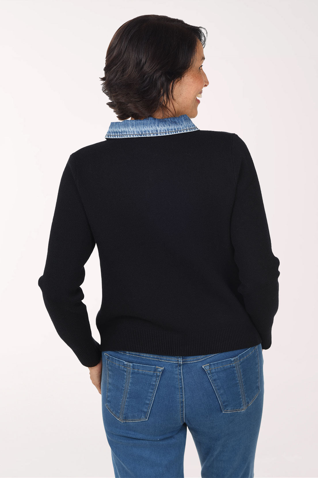 Woman wearing a black zip-up sweater jackets with a denim collar