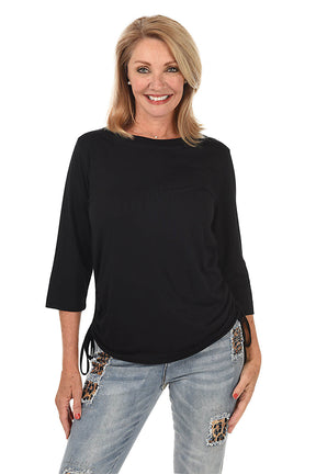 Woman wearing a black top and light blue jeans with leopard print accents on a white background