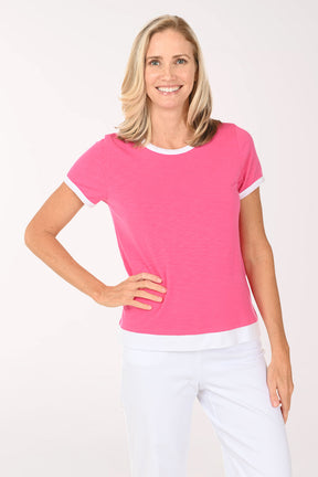 Woman wearing a pink t-shirt with white trim on a white background