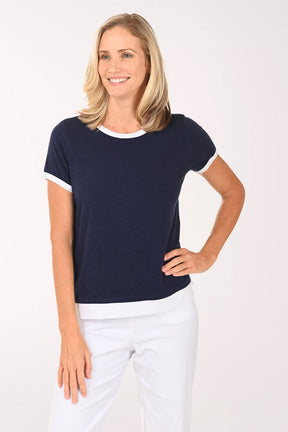 Woman wearing a navy blue t-shirt with white trim on a white background