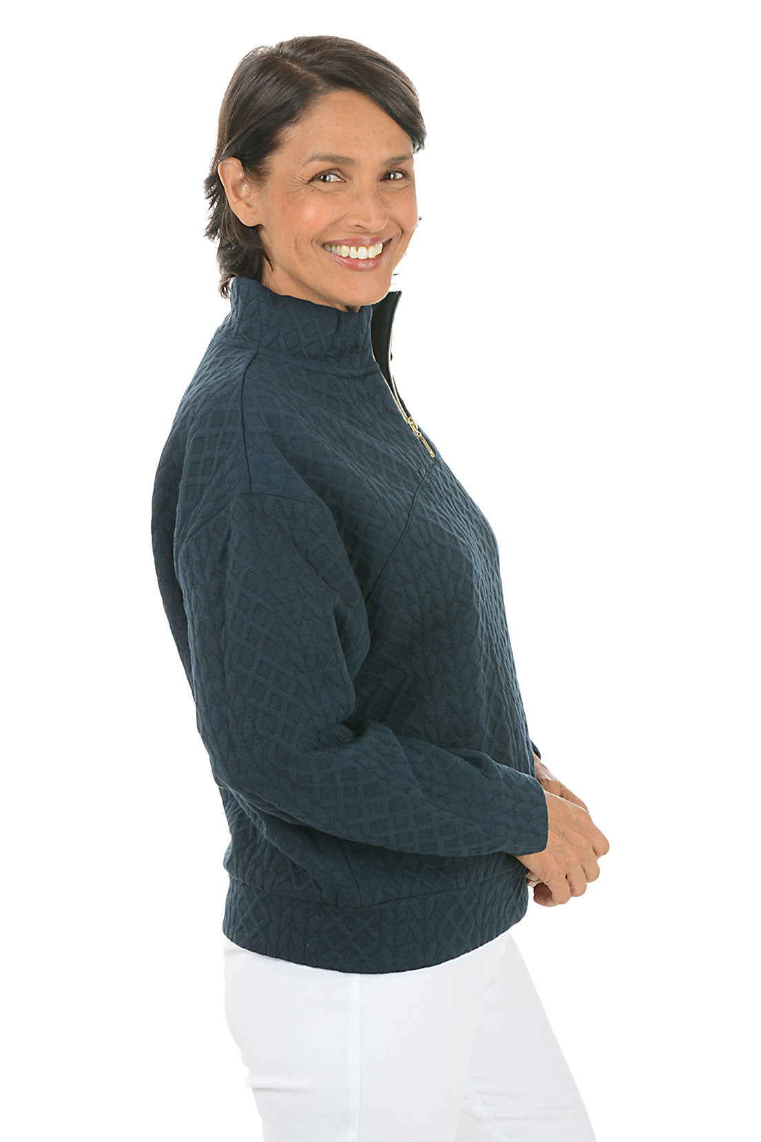 Woman wearing a dark blue pullover with a zipper on a white background. Side shot.