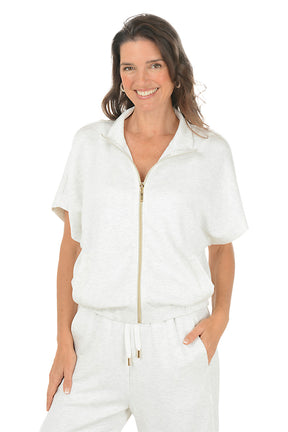 Woman wearing a white blue zip-up top with a white background.