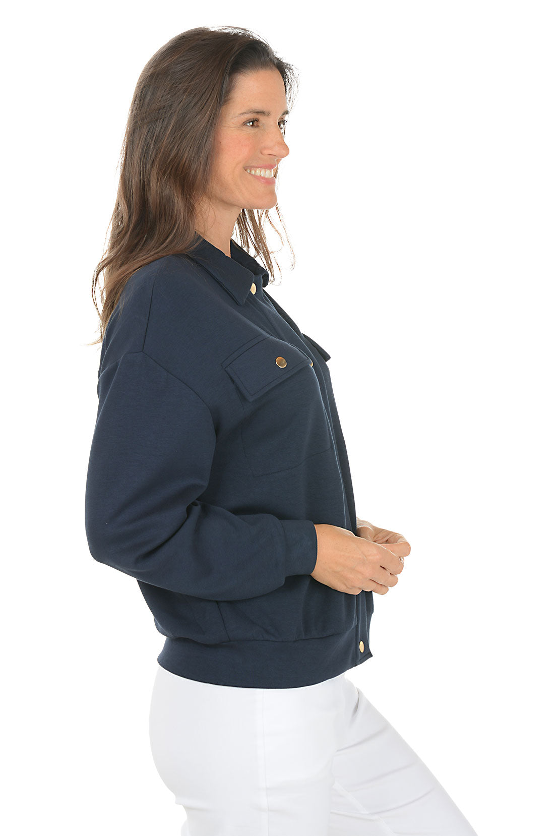 Woman wearing a navy blue jacket with gold buttons on a white background. Side shot.