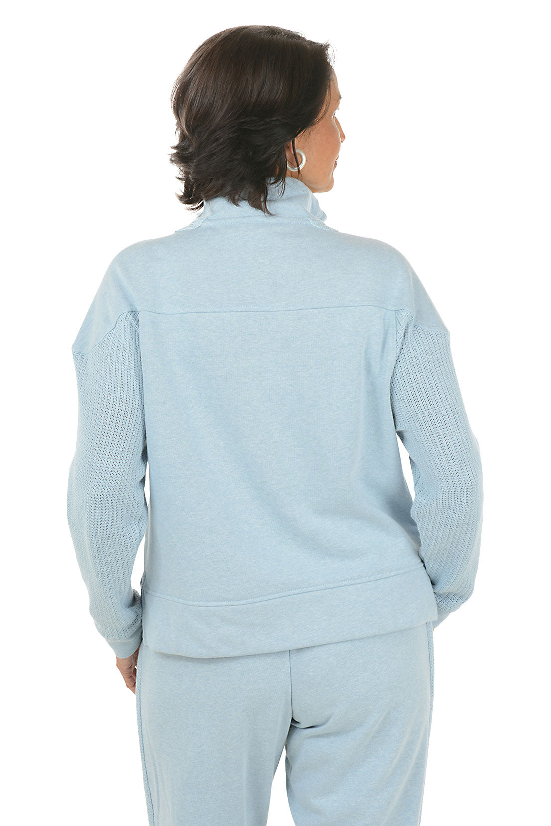 Woman wearing a light blue pullover with a quarter zip and matching pants on a white background. Back shot.