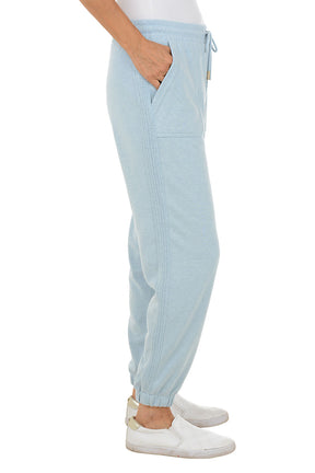 Light blue ribbed jogger pants worn by a person on a white background