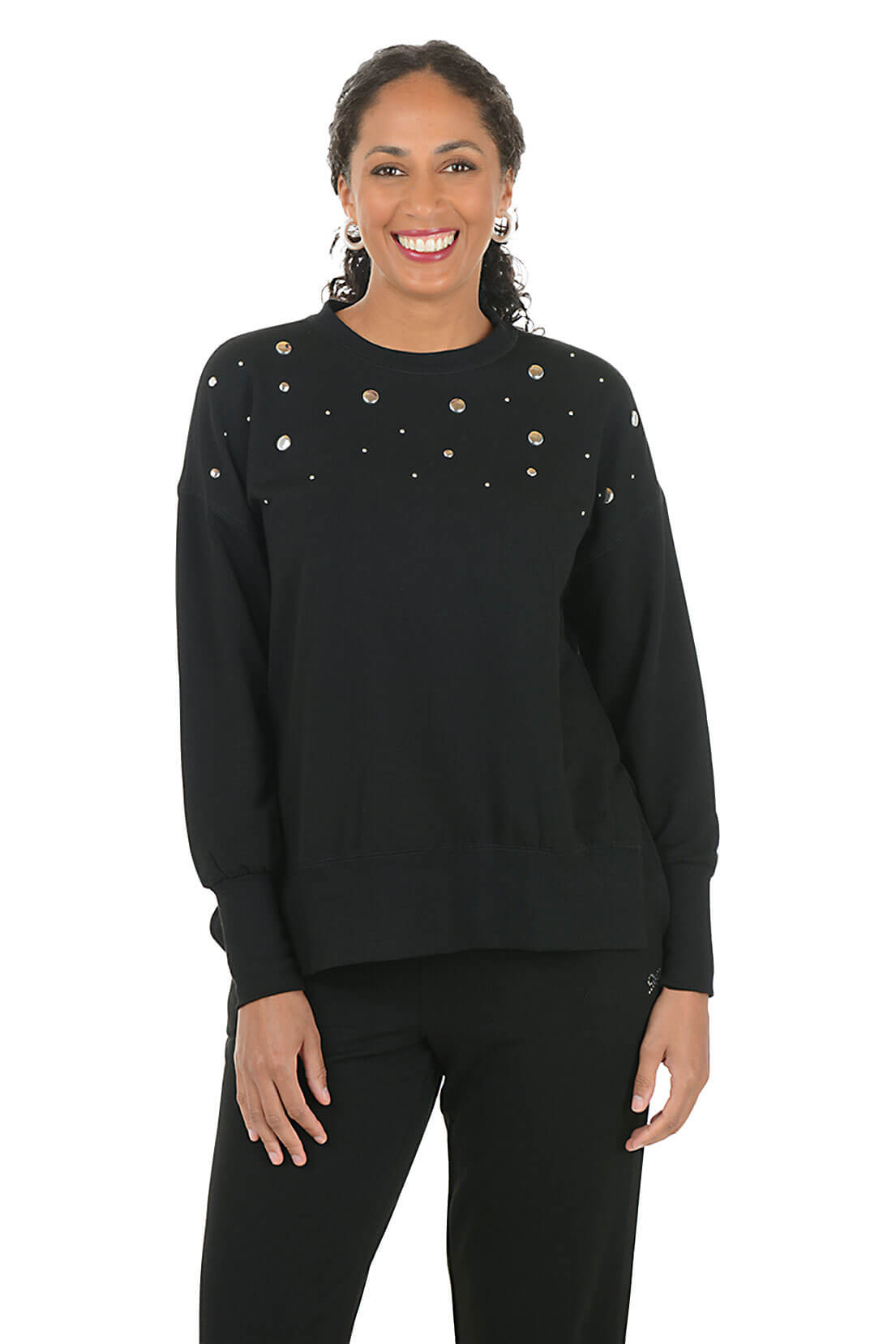 Woman wearing a black sweatshirt with embellishments on a white background