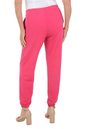 Pink jogger pants worn by a person on a white background