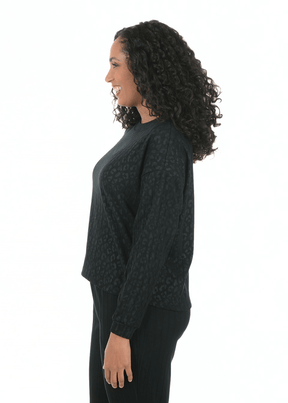 Woman wearing a dark green cable knit sweater on a white background