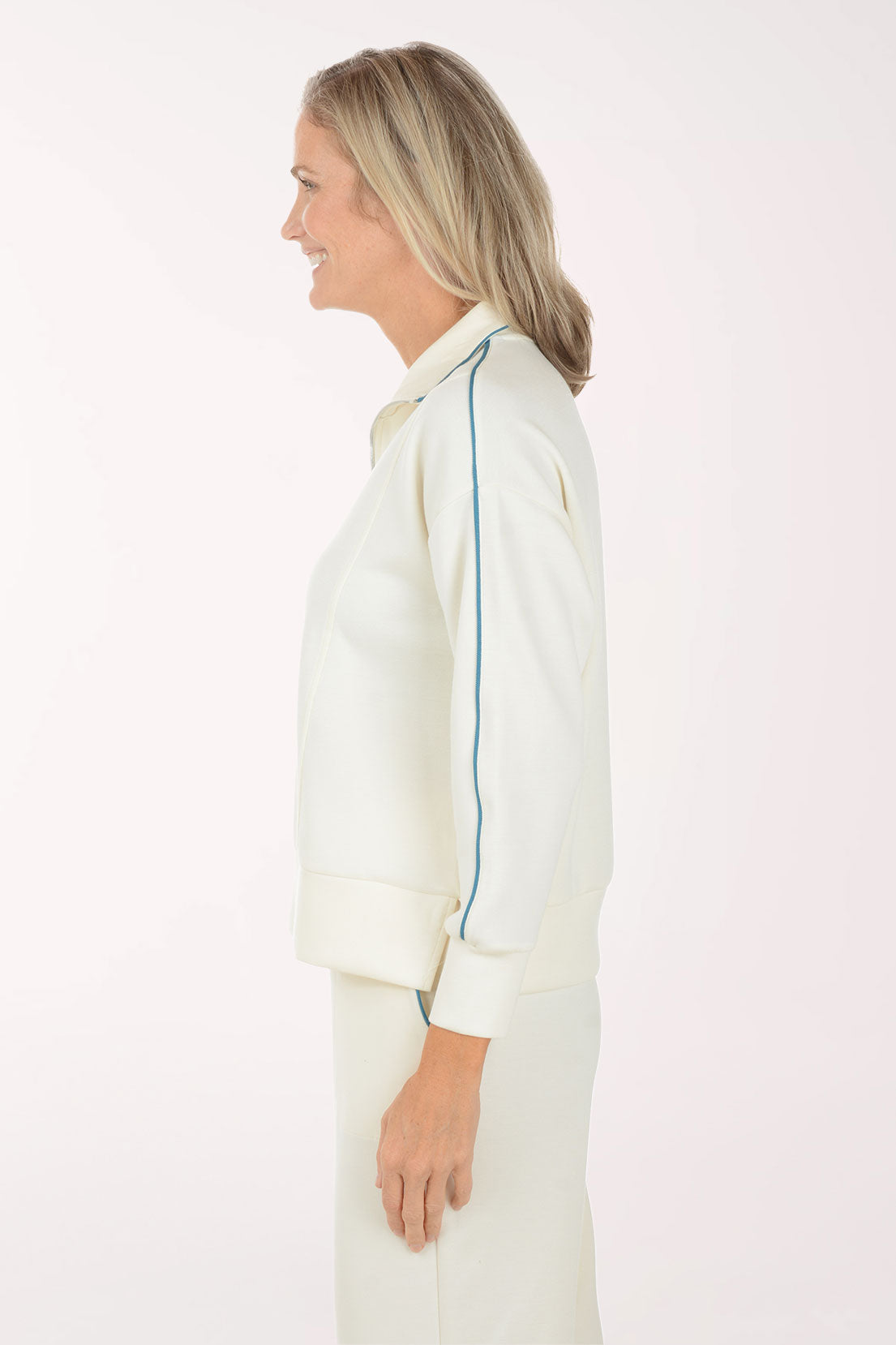 Woman wearing a cream-colored outfit with a white background